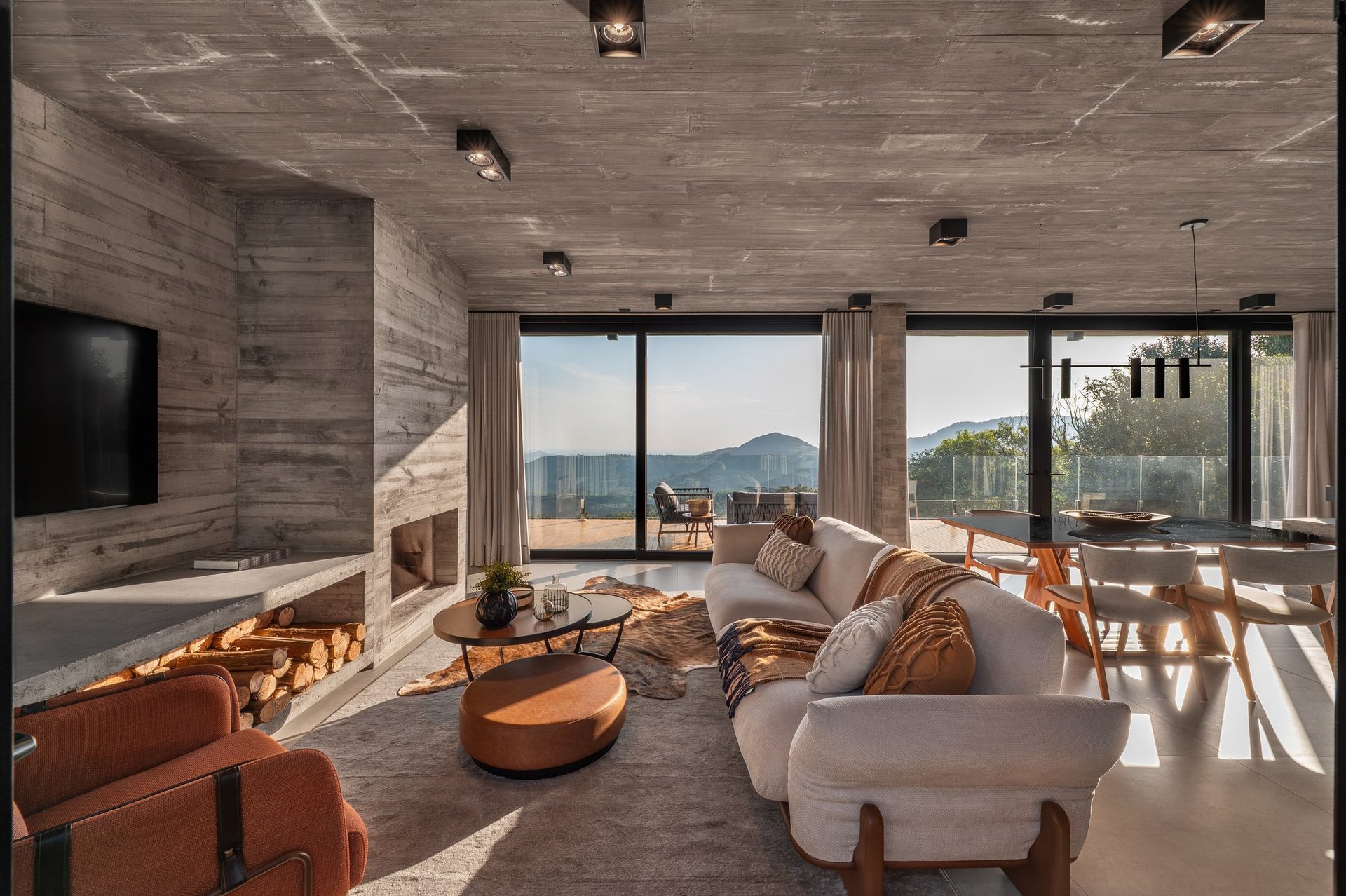Sala de estar com lareira e vista para as montanhas, em projeto da Arq. Márcia Fritzen